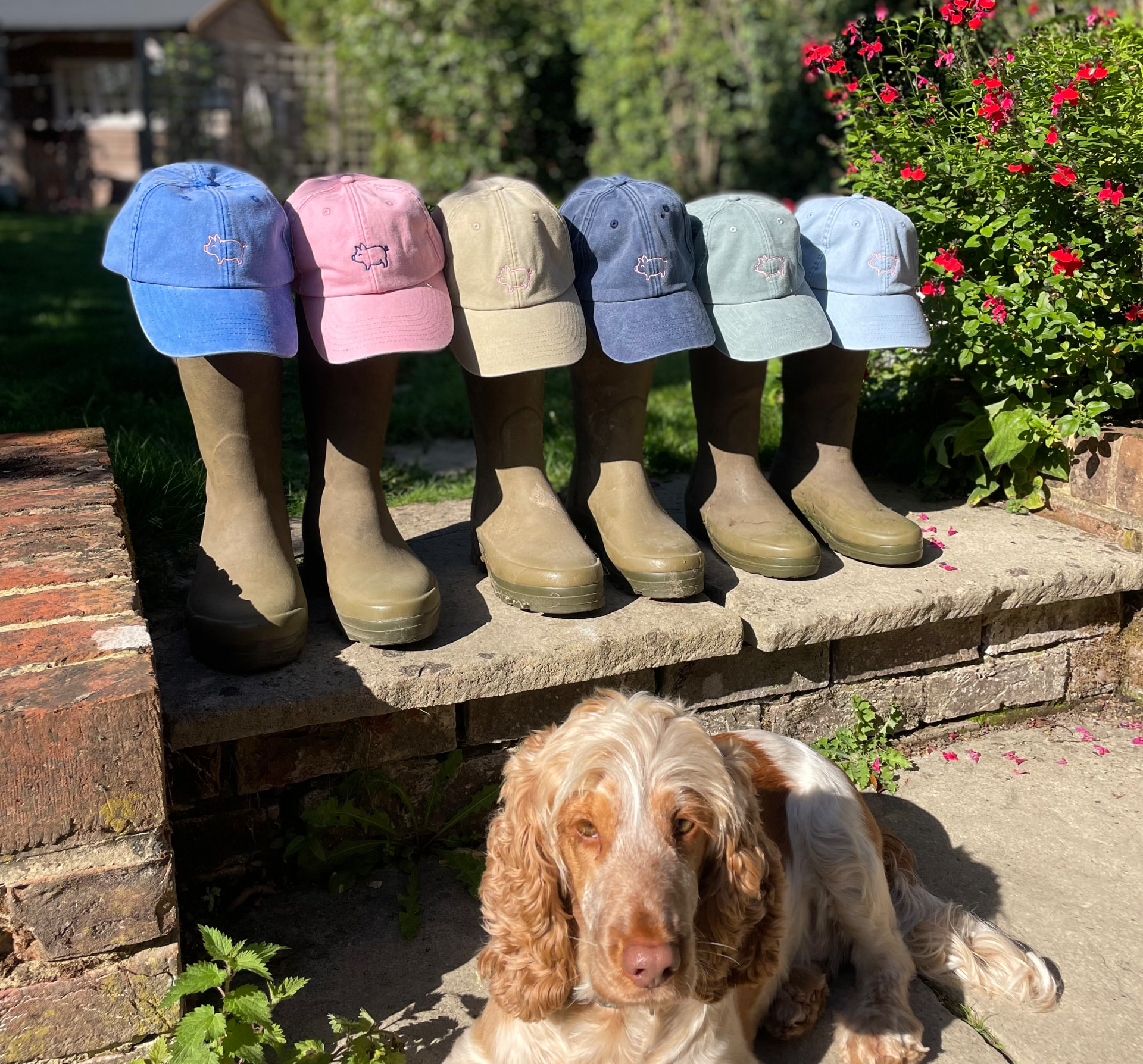 Tipsy Pig caps lined up on wellie boots