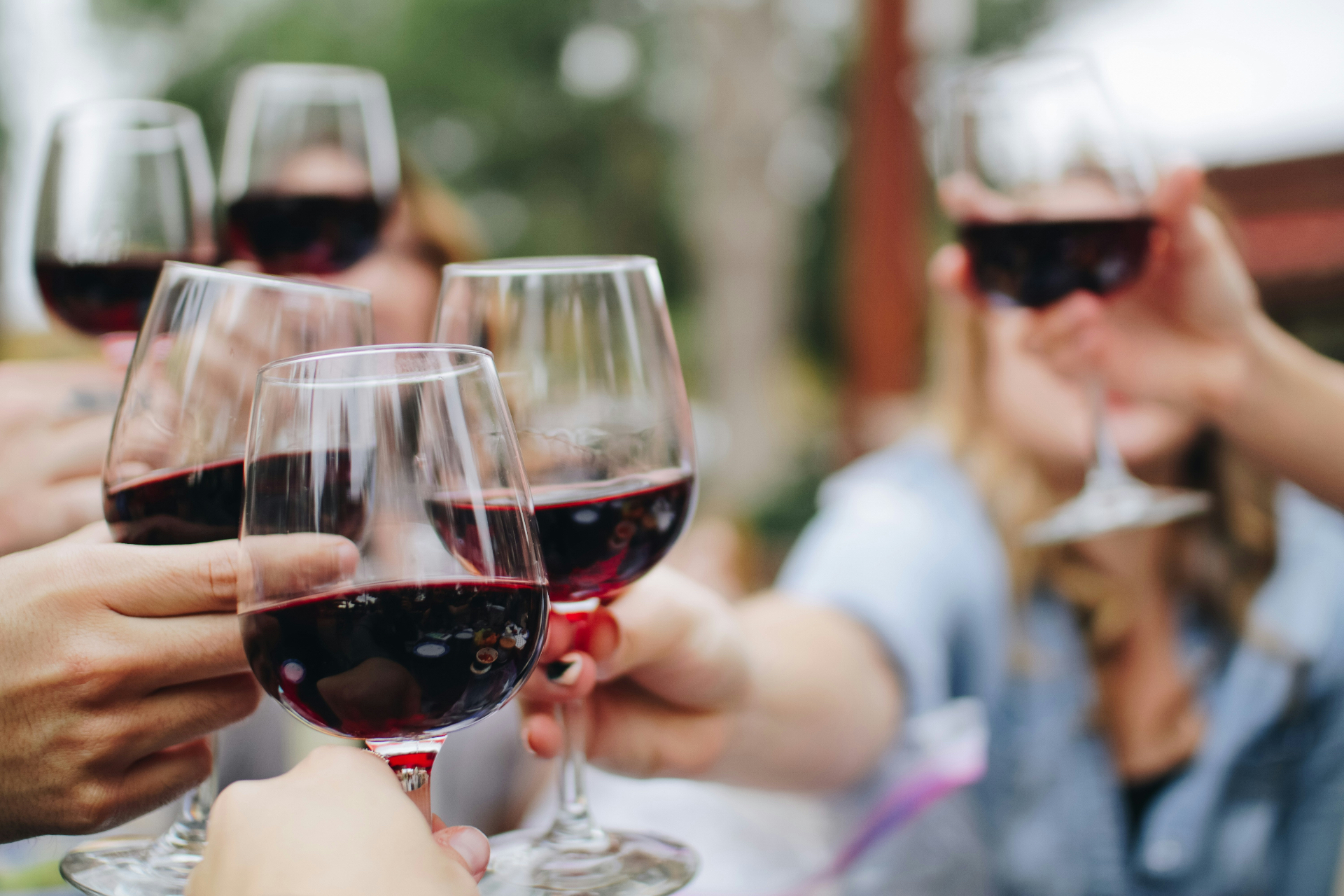 Friends clinking red wine glasses at a dinner party